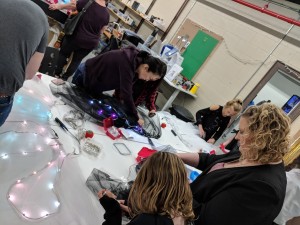 a group of people are sewing lights into their clothing at Fuse 33 makerspace