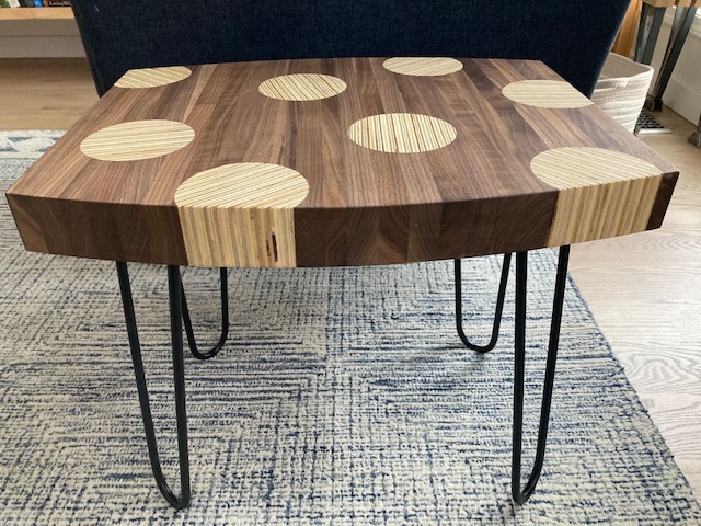a dark wood table with light polka dots built at Fuse 33 makerspace in Calgary