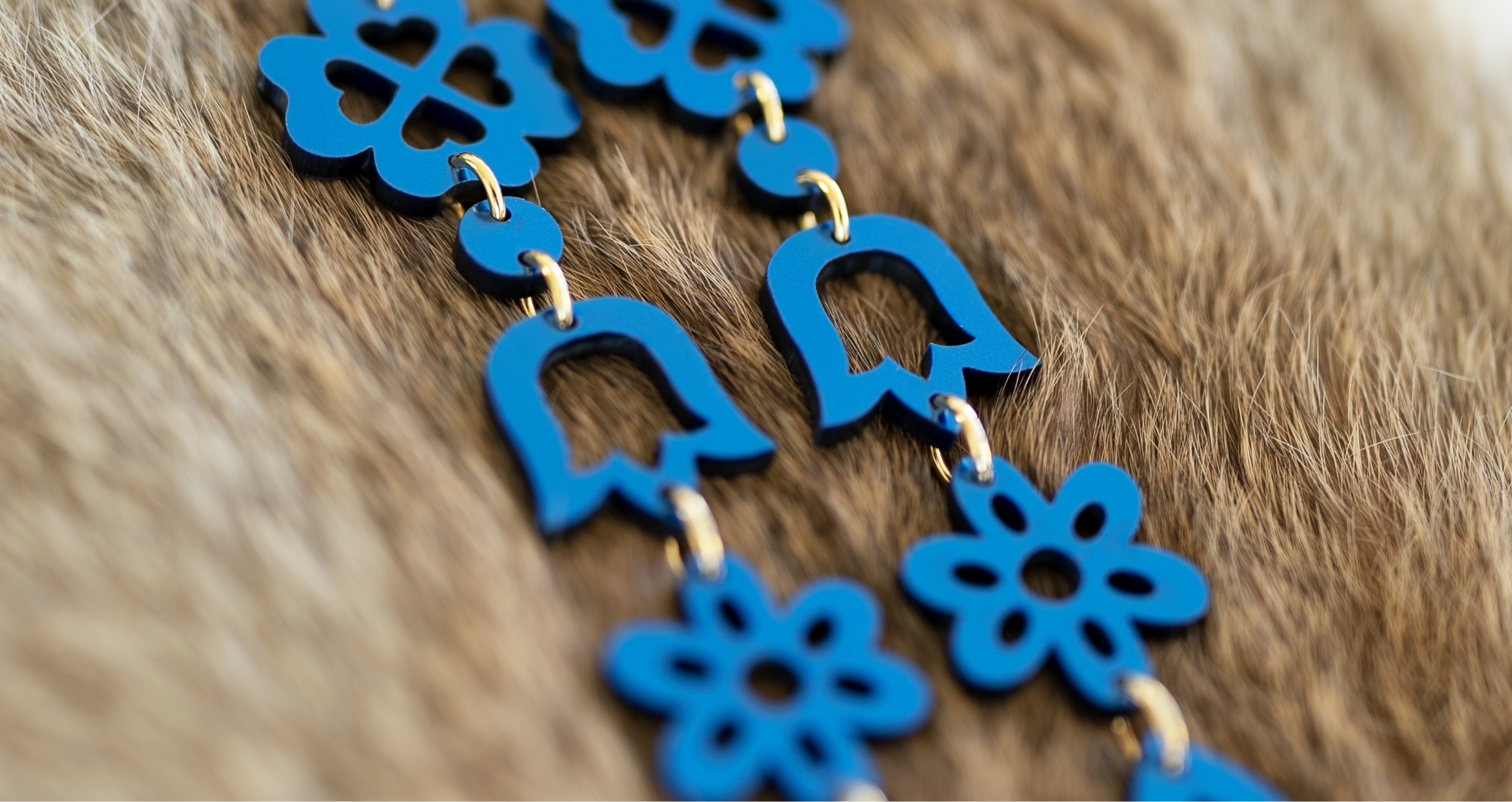 blue laser cut earrings several laser cut symbols hanging in a chain