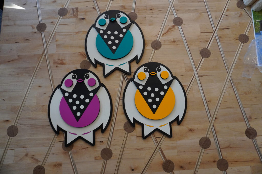 3 2D laser cut birds with polka dots on their chests. The birds are pink/magenta, teal and yellow