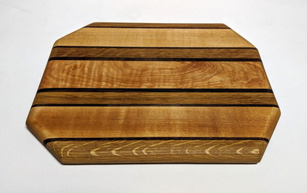 a wood cutting board made with joinery in different colors of wood in stripes.