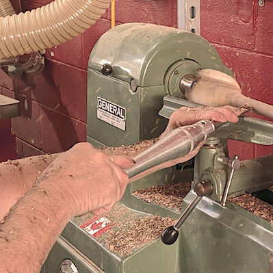 a man using a wood lathe machine at Fuse 33 makerspace calgary